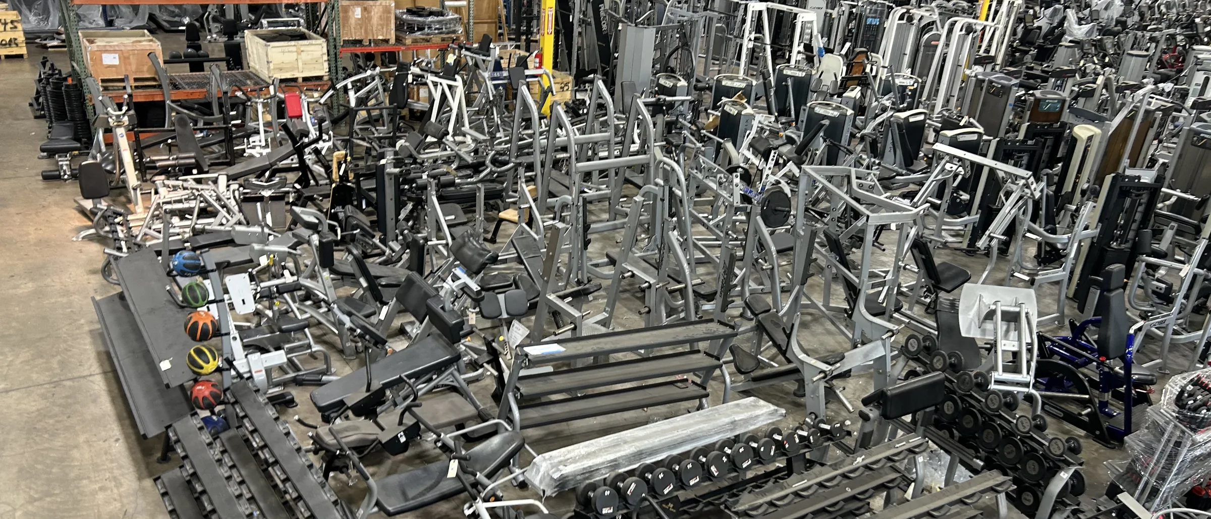 Racked cardio and strength inventory inside the DOF warehouse
